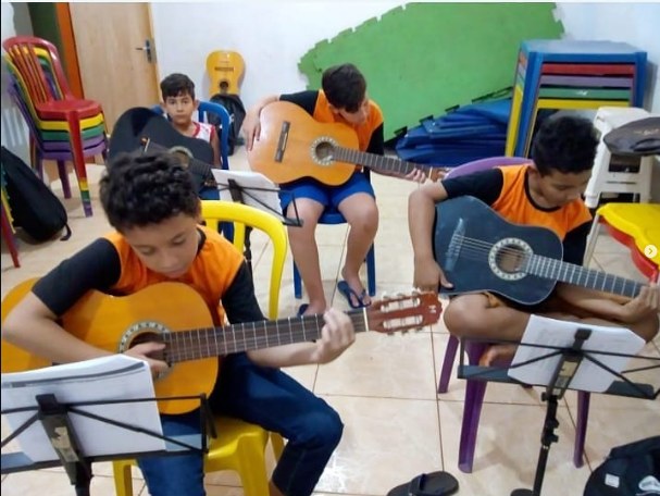 Participantes praticando violão